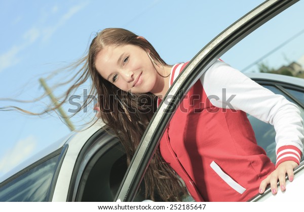 Car driver\
woman happy showing car keys out\
window