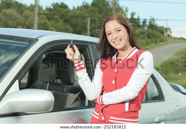 Car driver\
woman happy showing car keys out\
window