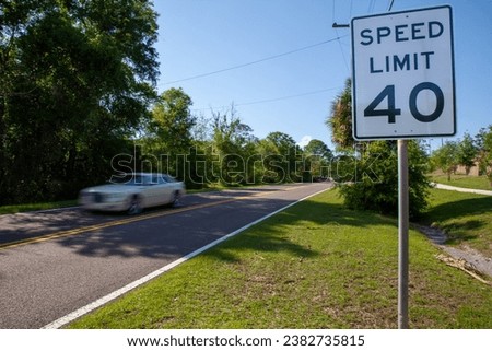 A car drives past the 40 mph speed limit sign on a country road in Florida - USA