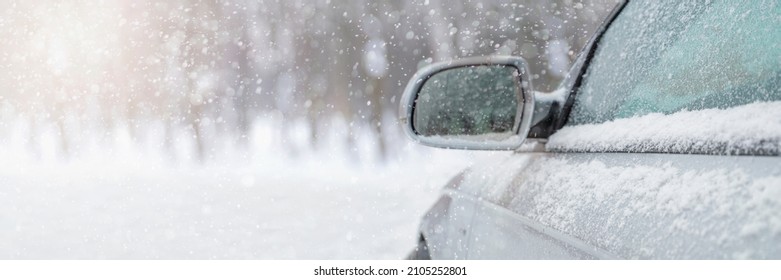 The car drives through the snow, the bright winter sun shines against the background of the forest. Close-up rearview mirror. The vehicle is covered with snow. Snowing. - Powered by Shutterstock