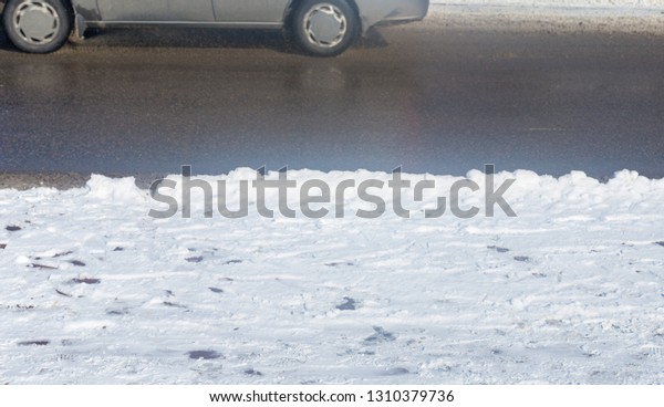 car drives in the\
winter on a dirty road