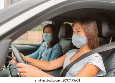 Car Driving Asian Woman Wearing Face Mask Inside During Coronavirus Pandemic. Driver With Passenger On Road Trip Drive.