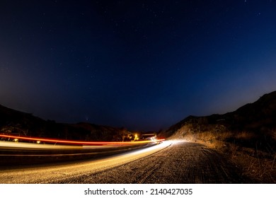 Car Driving Up Dark Road Under The Stars