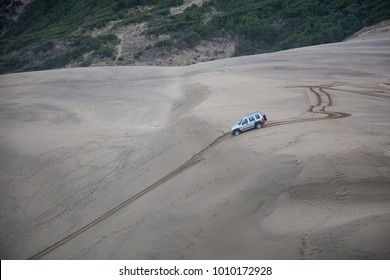 Car Driving Down The Steep Hill On A Sandy Beach In Oregon Coast.