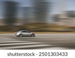 Car driving, fast motion on highway. Dynamic running car on road, blurred city background. Side view.