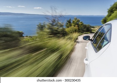 Car Driving Fast On A Mountain Road Towards The Sea