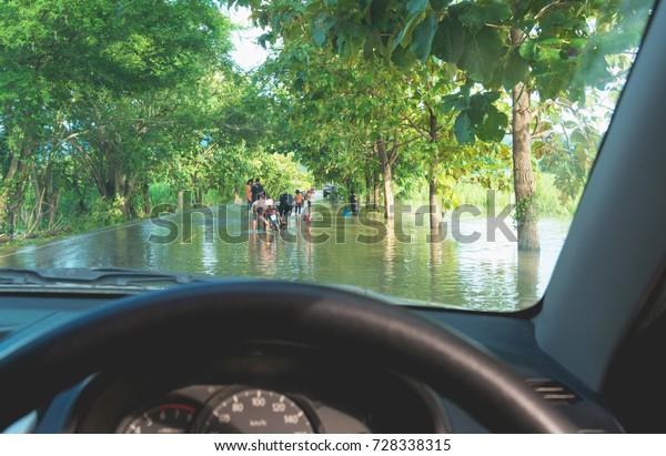 Car driving in heavy rain on a flooded
road. Car through flood water after hard
rain.