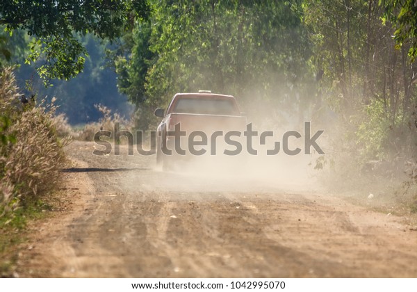 Car driving on dirt road
with dust