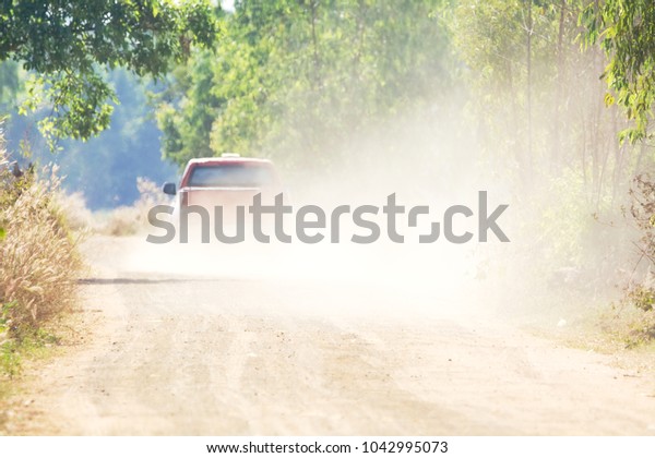 Car driving on dirt road\
with dust
