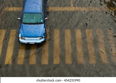 Car Driving On A Flooded Road.