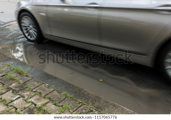Car driving on flooded road, Concrete asphalt\
cracks on the Street, Line rough surface and grey cracked asphalt\
road, Wheels ran over water