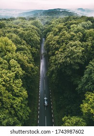 Car driving on a forest road seen from above. Aerial view.