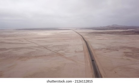 Car driving on gravel road in aerial desert. Sandy landscape, nobody. Wildlife, mountains. Nature in Namibia, Africa. Highway to Skeleton coast. SUV white automobile vehicle.