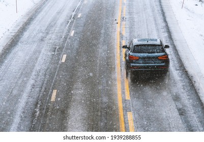 Car Driving On A Highway With Wet Slippery Asphalt During A Snow Storm. 