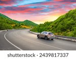 Car driving on mountain road landscape at colorful sunset. Beautiful nature scenery to travel on amazing highway landscape between green mountains. Turkey trip in green nature road. Uludag, Turkey.