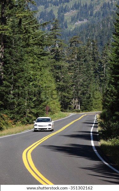 A car driving on a paved road at high elevations in
Rainier National Park.