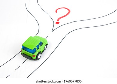 the car is driving on a road with a fork in the road and a red question mark, the concept of choosing the right path.