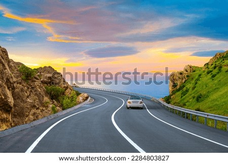 Car driving on the road in summer. highway landscape at colorful sunset. coastal road in europe. summer trip on the road on beautiful nature scenery. highway view on ocean beach.