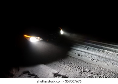 Car Driving On A Snowy Road In The Middle Of The Night