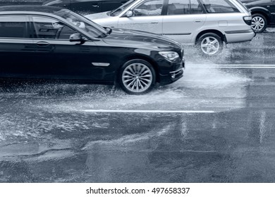 Car Driving On Wet Road With Splashing Water After Heavy Rain