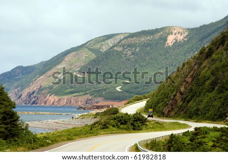 Car driving on winding Cabot Trail in Cape Breton Highlands National Park, Nova Scotia