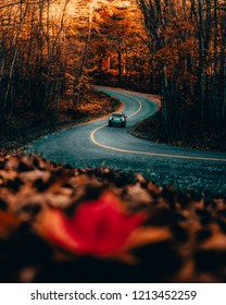 CAR DRIVING ON WINDING ROAD IN AUTUMN/FALL - Beautiful Warm Seasonal Scene Of Car Driving Along Curved Back Country Road At Sunrise. Exploring And Travelling Canadian Countryside. Ontario, Canada.