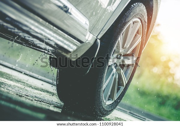 Car Driving in the
Rain. Modern Rain Summer Season Tires on the Wet Pavement. Closeup
Aquaplaning Photo.