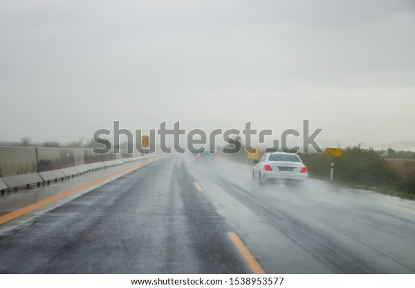 car\
driving in rainy weather in wet and slippery\
road