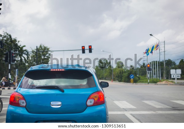 car\
driving stopped on crossroad with red traffic\
light