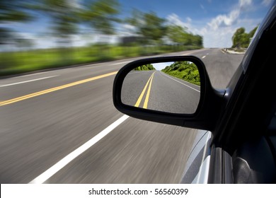 Car Driving Through The Empty Road And Focus On Mirror