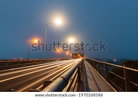 Car driving through fog at Ryde Bridge, Sydney, Australia.