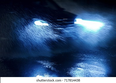 Car Driving Through Heavy Rain With Switched On Blue Headlights