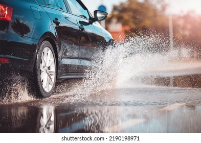 Car driving through the puddle and splashing by water.