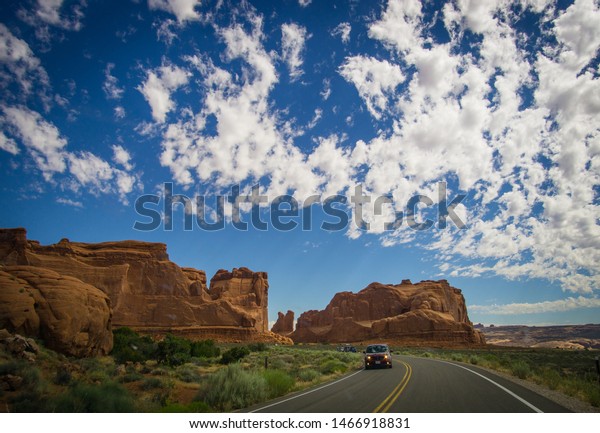 car driving\
through road in arches national\
park