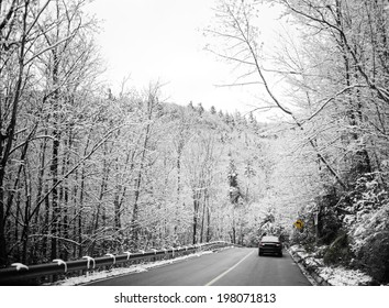 A car driving through a snowy, winter scene.