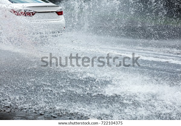 car driving through water puddles. rain pouring on city\
road. 
