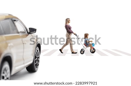 Car driving towards a mother pushing a child on a tricycle at a pedestrian crossing isolated on white background