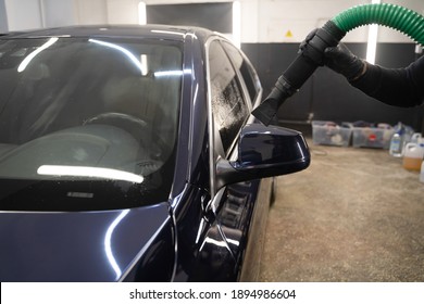 Car drying process after washing. Man with vacuum cleaner removes water droplets from car. Professional auto wash concept - Shutterstock ID 1894986604
