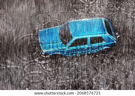 The car  during the rain drowns in a huge puddle formed as a result of the flood. Photo effect: water droplets on glass