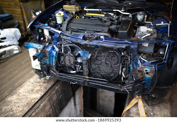 car\
is in emergency condition, disassembled hood and bumper, broken\
radiator and ventilator. Car crash recovery\
concept