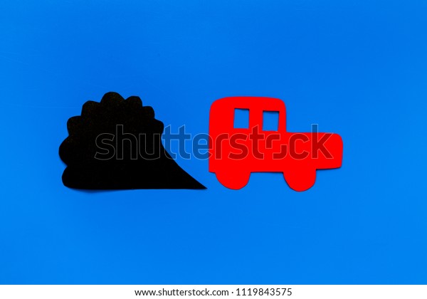 Car emitting dirty\
smoke. Pollution conept. Car and smoke cutout on blue background\
top view copy space