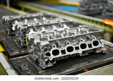 Car engine cylinder heads in housings on conveyor in shop - Shutterstock ID 2222531519