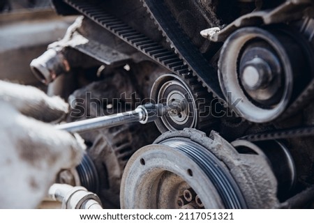 the car engine is disassembled from the side of the belt and the timing rollers at a shallow depth of field