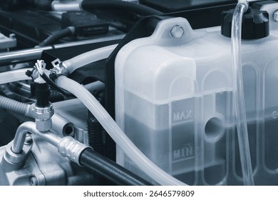 Car engine with a hose attached to a container of liquid. transport concept background