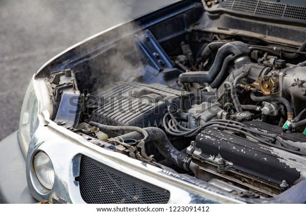 Car engine over heat with no water in radiator\
and cooling system.\
Overheated car machine Broken down with\
smoking, overheating engine on the road.\
Automotive motor problem\
concept.