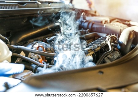 car engine overheating close up. vehicle engine in smoke. smoke or steam from a vehicle engine
