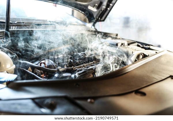 car engine overheating close up. vehicle engine in\
smoke. short circuit in the car motor. car wiring fault. smoke or\
steam from a vehicle engine