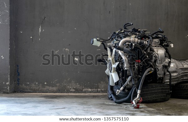 car engine repair in garage with soft-focus\
and over light in the\
background