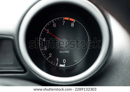 Car engine rev meter or tachometer showing 5000 rpm . Close up shot, no people.