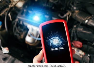 Car engine scanning with wireless technical tool, OBD2 scanner tool in a mechanic hand with a car engine compartment blurred on background, Car maintenance service concept
